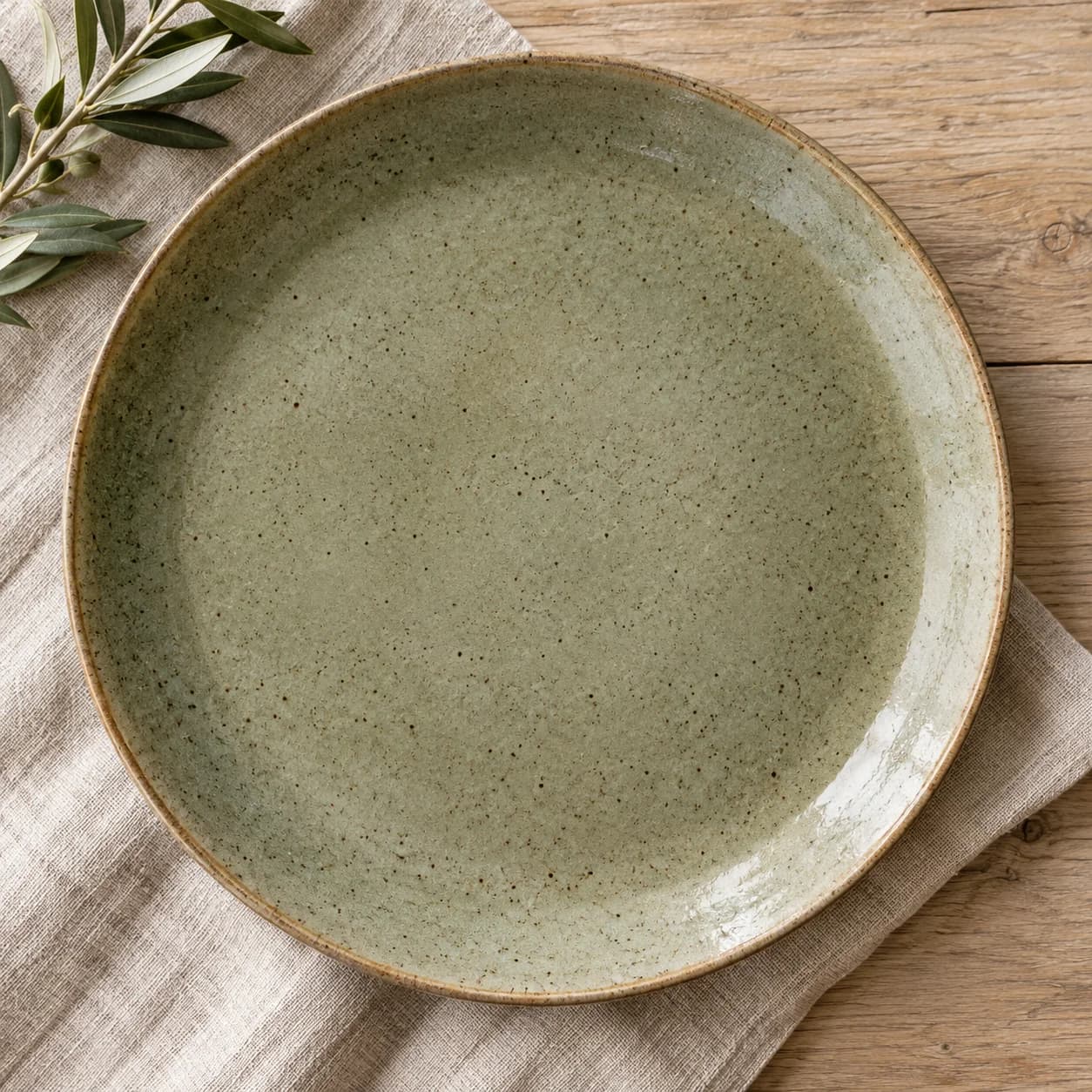 Speckled stoneware dinner plate on a linen table